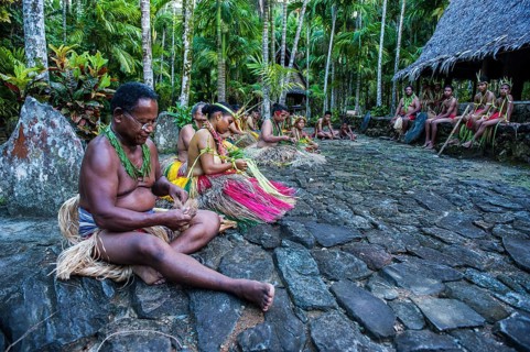 Traditionally dressed islanders making traditional art work