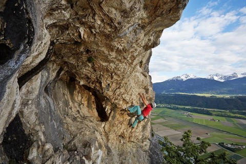 Freeclimber with helmet climbing on a rock face