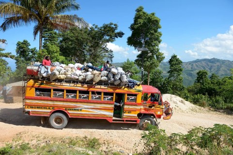 Overcrowded bus on a dusty road in the mountains