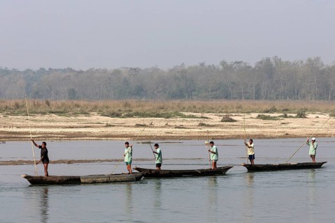 Nepalese men in dugouts on the East Rapti River at Sauraha