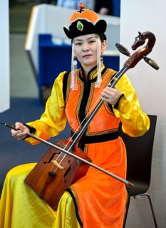 Mongolian musician is playing the horse-head fiddle or Morin Khuur