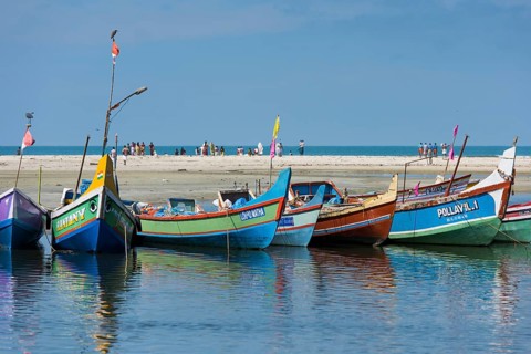 Brightly painted fishing boats and people on the beach