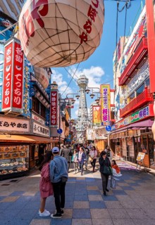 Many colorful advertising signs in a pedestrian zone with shops and restaurants