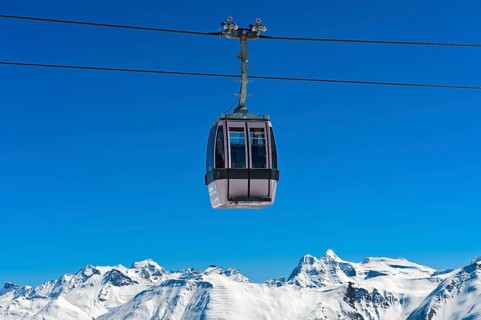 Gondola of the Moosfluh cable car in front of the snowy mountain range of the Valais Alps