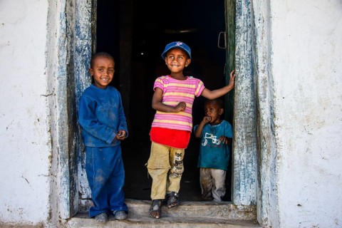 Young children standing in a door frame