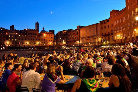 Crowded tables of the restaurants on the track of the Palio di Siena after the race