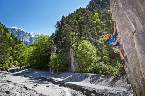Sport climber wearing a helmet climbing a rock face