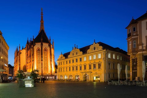 The illuminated Falkenhaus building and the Marienkapelle church