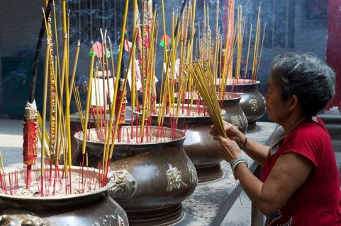 Woman lighting incense sticks
