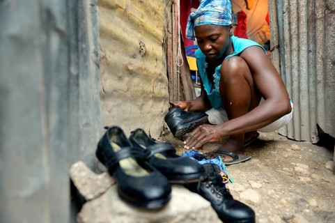 Woman shining the shoes of her children for their first day of school