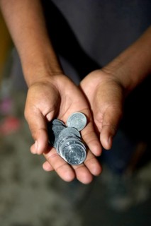 Panhandled money in the hands of a street child