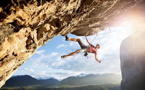 Freeclimber with helmet climbing on a rock face