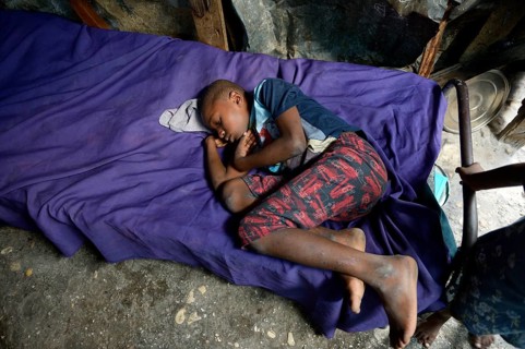 Boy is sleeping on a bed in barracks