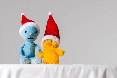 Two plush toys wearing Santa Claus hats