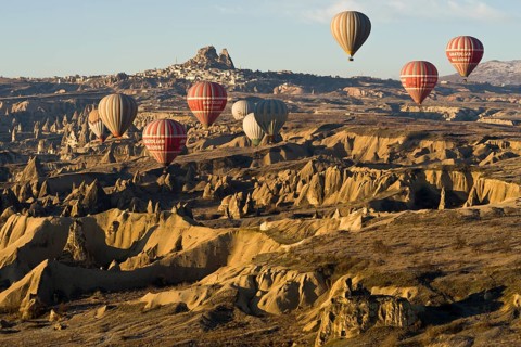 Hot air balloons in front of the Castle of Uchisar