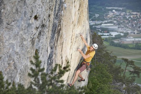 Freeclimber with helmet climbing on a rock face