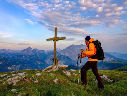 Mountaineer at the summit cross of the Hochsaul
