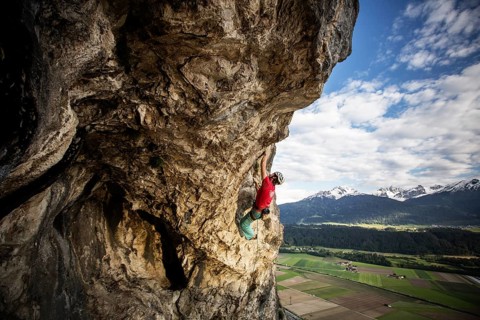 Freeclimber with helmet climbing on a rock face