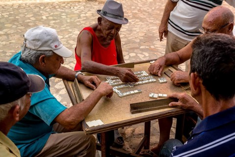 Cuban men playing dominoes at a table outside