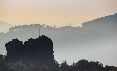 Bruchhauser Steine rocks with a group of visitors at the summit cross