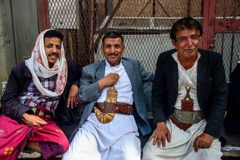 Men with their djambias sitting in front of a house in the old city