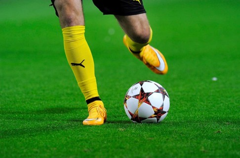 Legs of a BVB player with adidas Champions League Ball