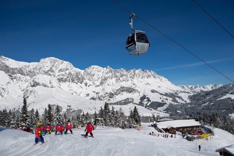 Skiers on ski slope in front of mountain scenery