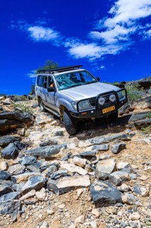 SUV driving down steep rock steps