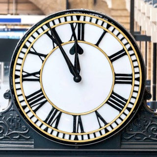 Railway station clock showing 11:55