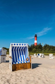 Beach chair on the beach in front of the lighthouse