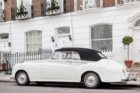 A Rolls Royce Silver Cloud parked in front of a row of houses in the exclusive district of Knightsbridge