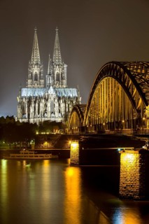 The illuminated Cologne Cathedral and Hohenzollern Bridge at night with Rhine