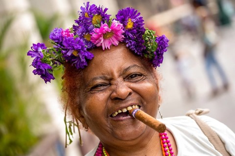 Elderly Cuban woman with flower headdress and cigar