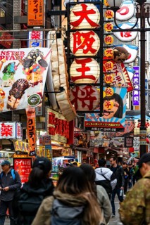 Crowd crowded in pedestrian zone with lots of advertising signs for restaurants and shopping centers