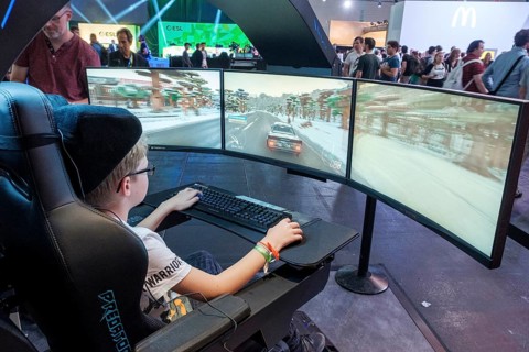 Junge plays simulation of a car race at Gamescom