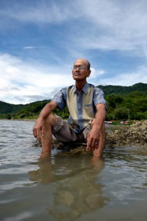 Aged man gazing over the sea after losing almost his entire family to the 2004 tsunami