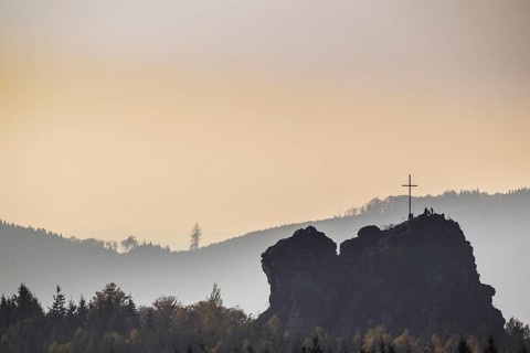 Bruchhauser Steine rocks with a group of visitors at the summit cross