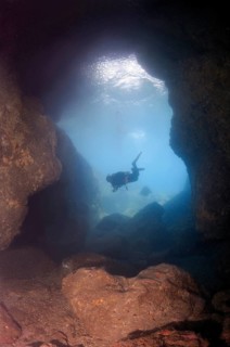 Diver looking into a cave