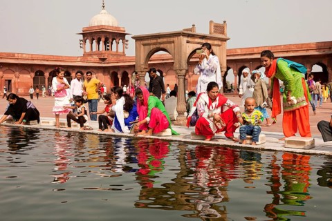 Devout Muslims purifying themselves in the water basin of the Friday Mosque Jama Masjid