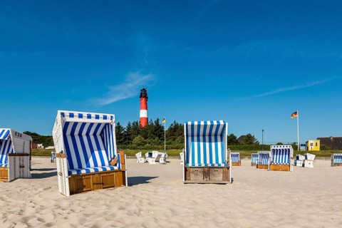 Beach chairs on the beach in front of the lighthouse