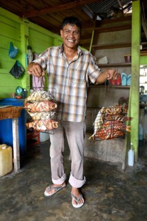 Man presenting grilled fish in restaurant