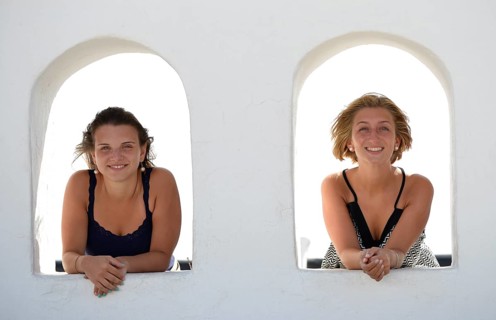 Two young women looking out from the Balcon de Femes