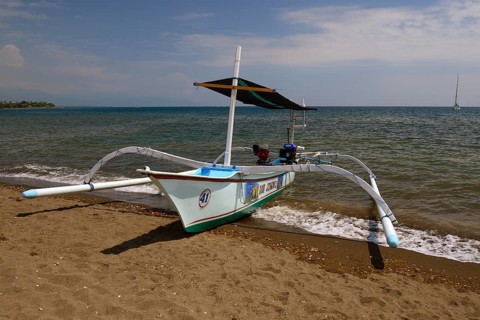 Traditional outrigger boat on the black lava beach