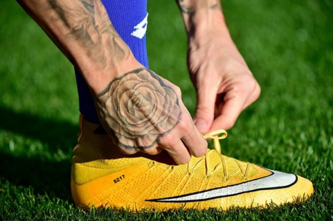 Football player tying the laces of his soccer shoes