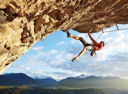 Freeclimber with helmet climbing on a rock face