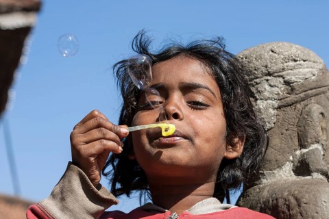 Nepalese girl making soap bubbles