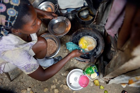 Woman cooking in the improvised kitchen of a ramshackle hut