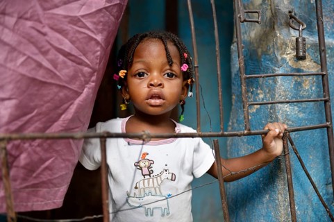 Girl behind a fence in a doorway