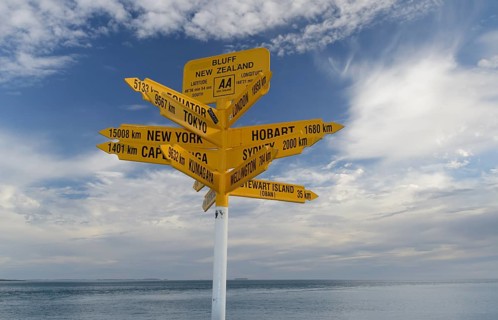 Yellow signposts with worldwide destinations