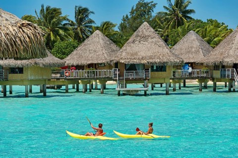 Paddlers in front of overwater bungalows